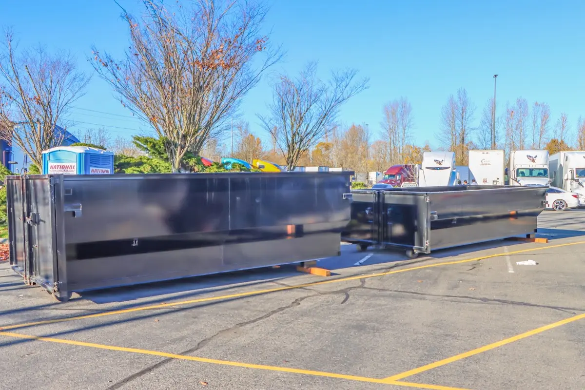 Professional dumpster rental service with roll-off container on residential driveway in Huntley